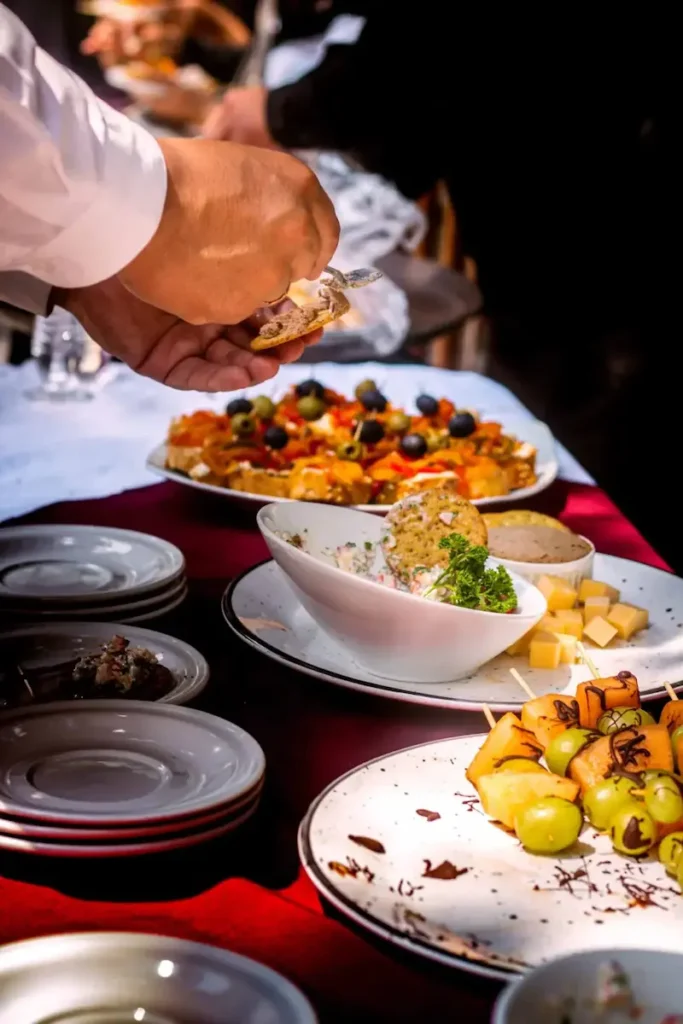 close-up sur un cocktail dinatoire. les mains d'un homme se servent de la nourriture